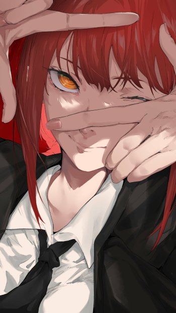 Phone wallpaper of Makima (Chainsaw Man): close-up anime portrait with red hair, golden eyes, a winking expression framed by hands, wearing a black suit and tie.