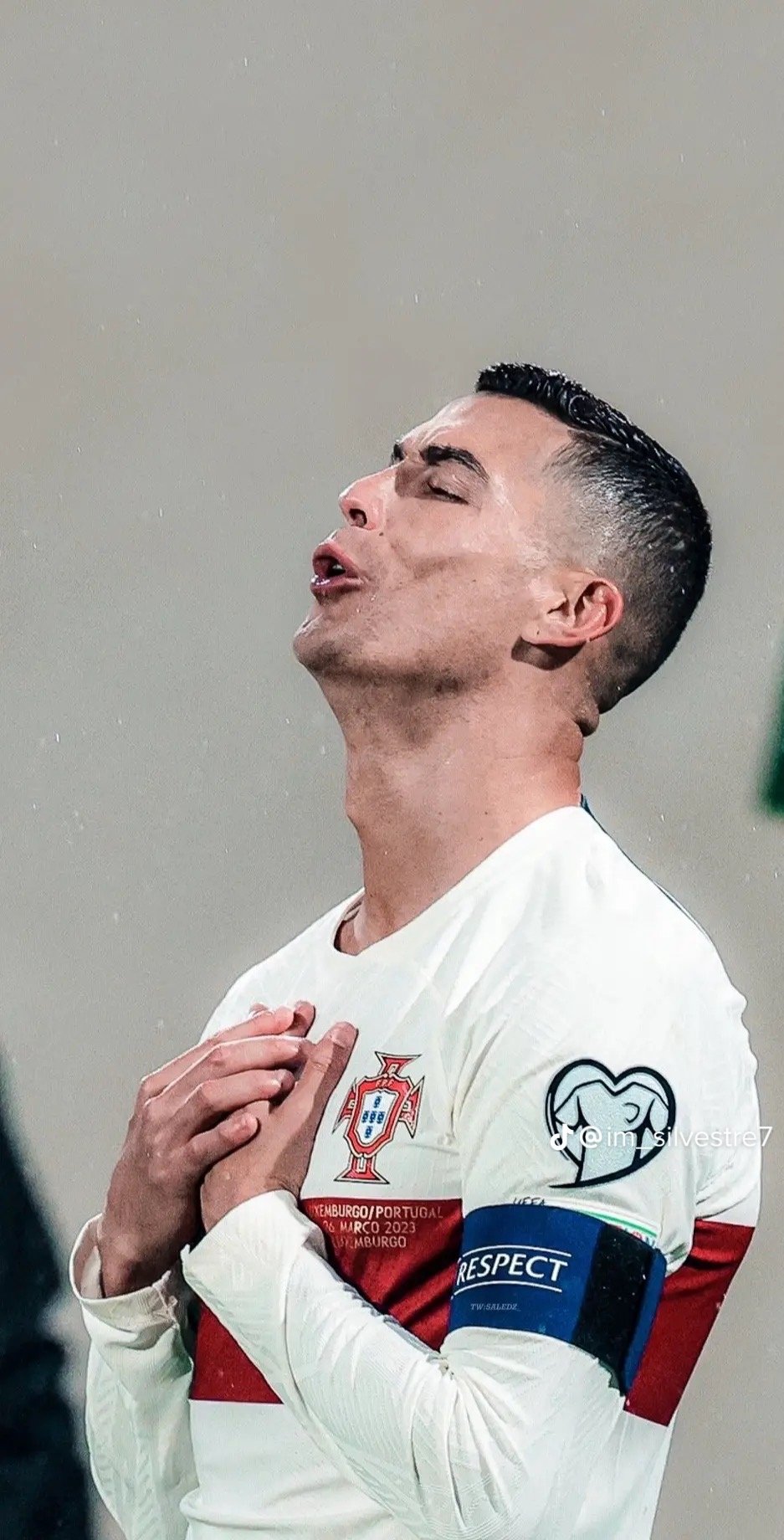 Phone wallpaper featuring a close-up of a soccer player in a Portugal jersey with captain's armband, captured in an emotional moment during a match.
