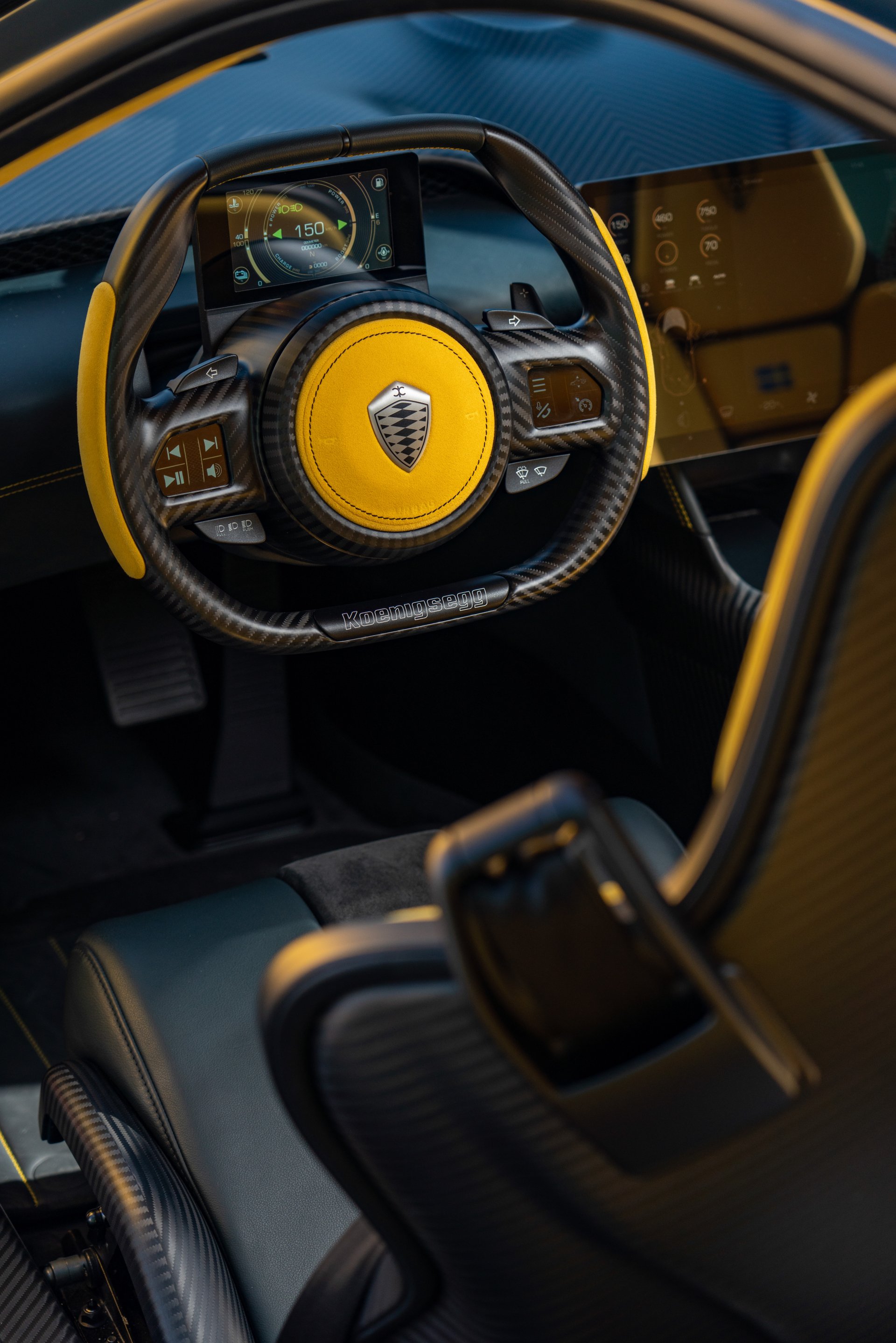 Close-up of the Koenigsegg Gemera’s interior, showcasing a stylish steering wheel and luxury detailing, set as a sleek phone wallpaper.