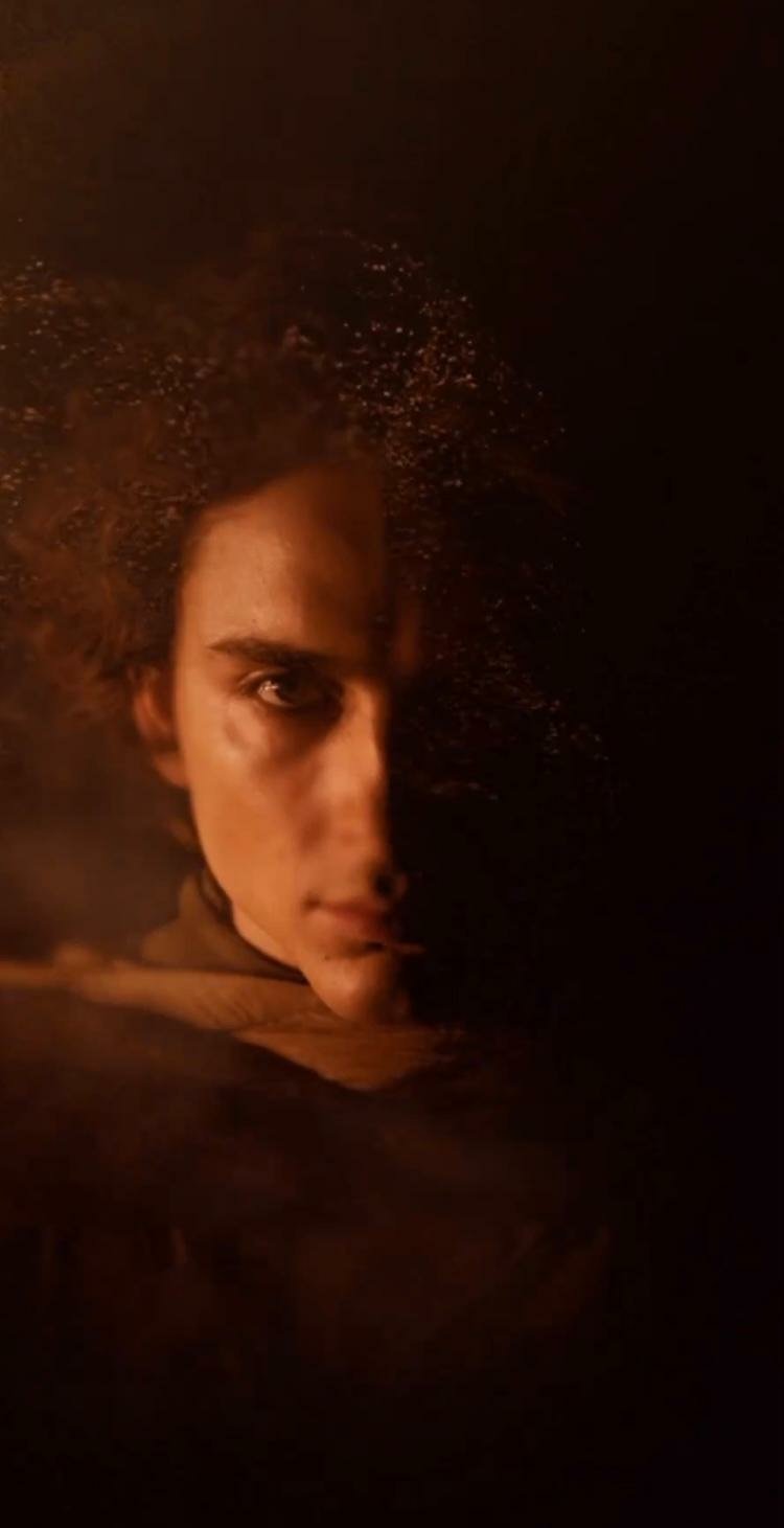 Dune: Part Two themed phone wallpaper featuring a close-up of a character shrouded in shadows with intense gaze.